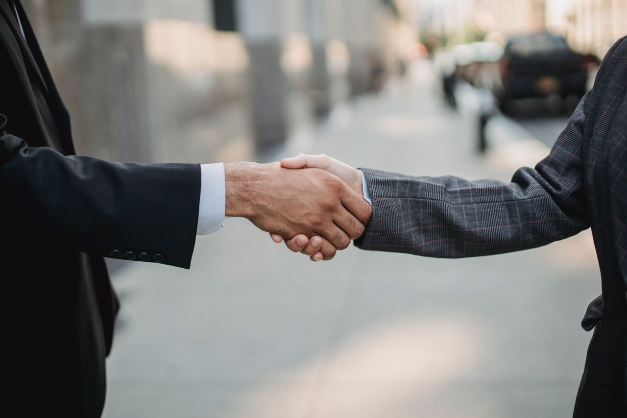 Aperto de mão entre entrevistador e candidato ao final de uma entrevista de emprego